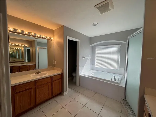 a bathroom with a bathtub sink and mirror