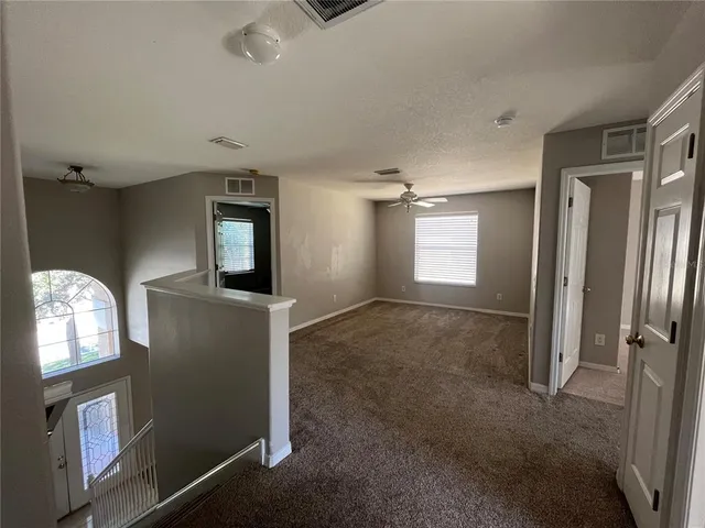 an empty room with a ceiling fan and closet area