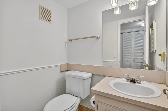 a bathroom with a granite countertop toilet sink and mirror
