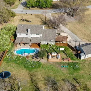 an aerial view of residential houses with outdoor space and swimming pool