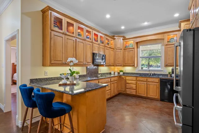 a kitchen with stainless steel appliances granite countertop a stove a sink and a refrigerator