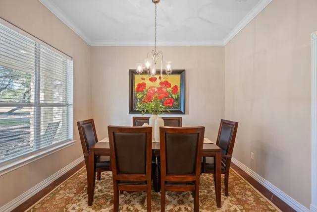 a view of a dining room with furniture a chandelier and wooden floor