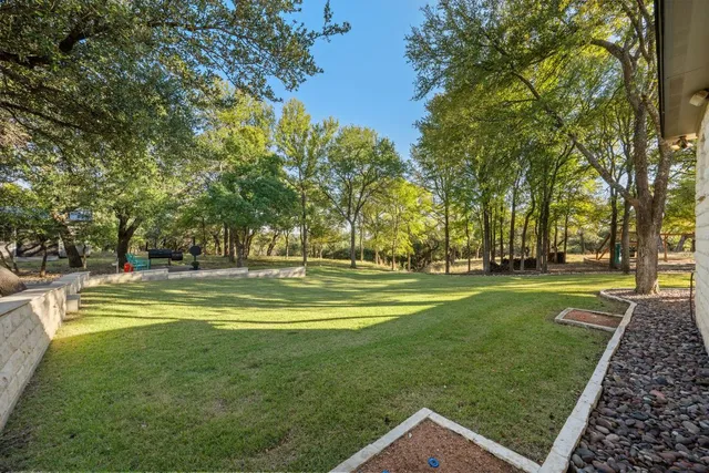 a view of a swimming pool with a garden and trees