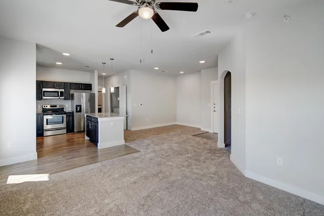 a view of a kitchen with a refrigerator and a stove top oven