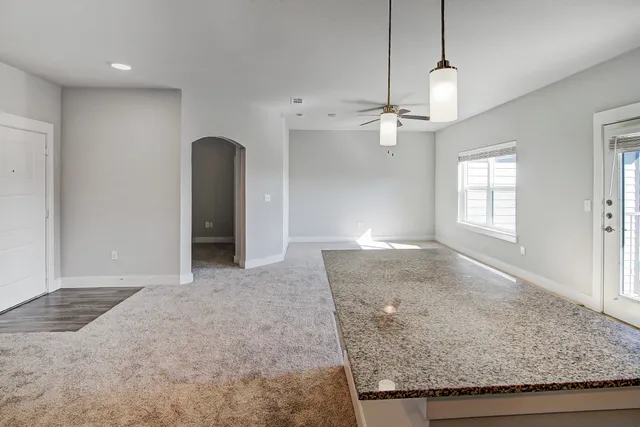 an empty room with a window and a fan