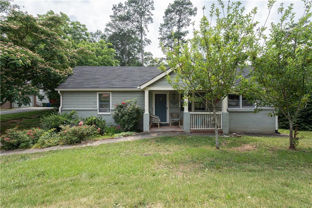 a front view of a house with a yard and trees