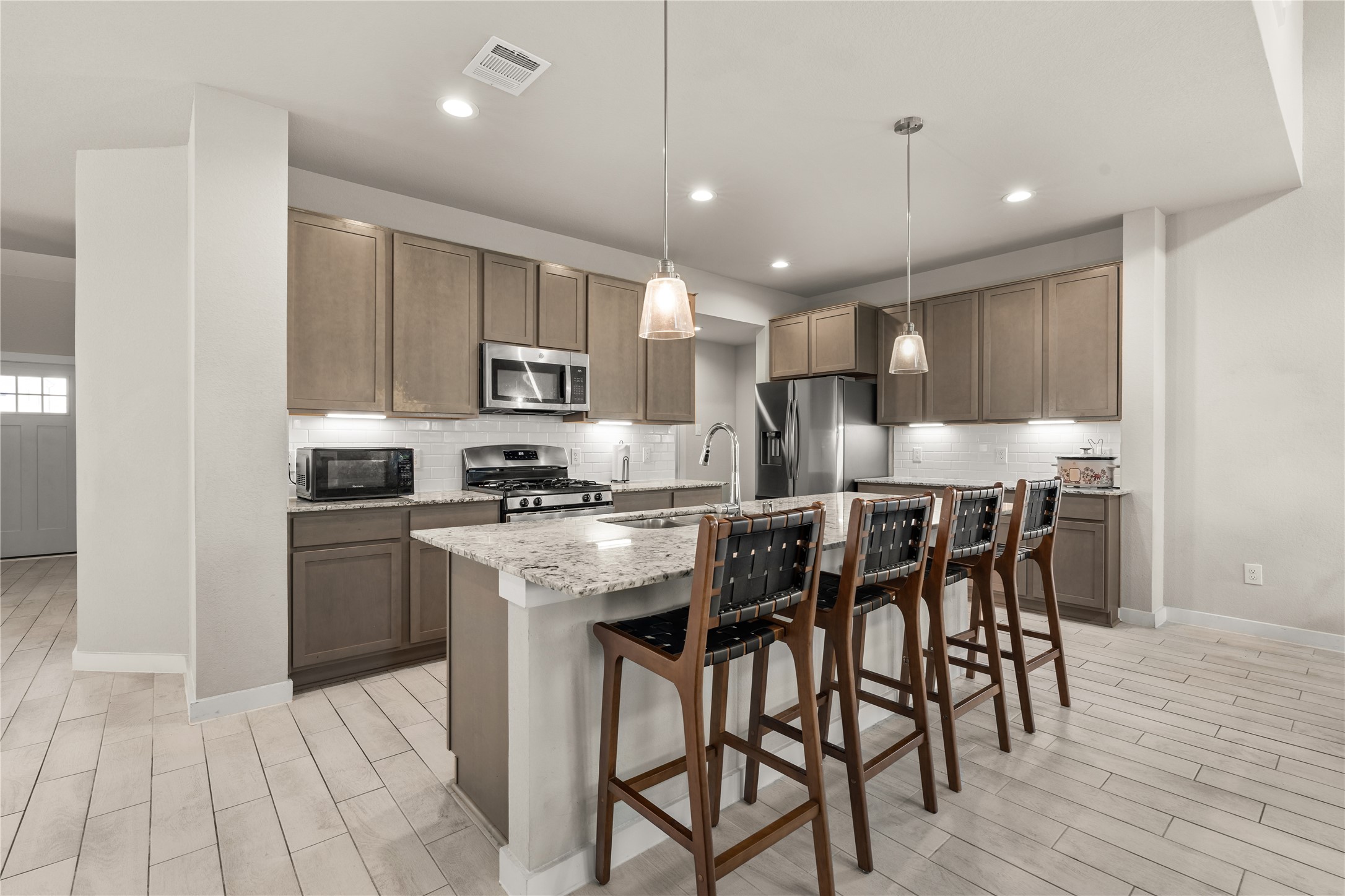22939 Aspen Vista Dr Spring Spring, TX 77373 - Photo 6 of 29 Designed with both everyday living and entertaining in mind, the open kitchen features a large center island, abundant cabinetry, generous prep space, and seamless views into the main living area.