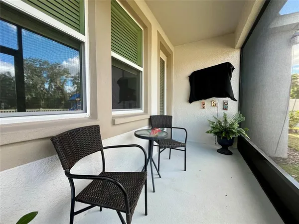 a view of an chairs and table in the patio with a barbeque grill
