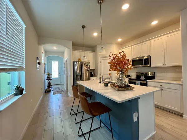 a kitchen with a sink a microwave and chairs