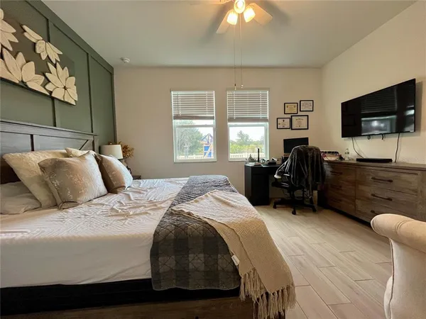 a bed room with a bed television and a large window
