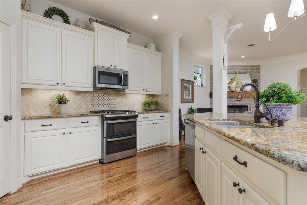 2205 State Boulevard McKinney, TX 75071 - Photo 10 of 40 a kitchen with stainless steel appliances granite countertop a stove a sink and white cabinets