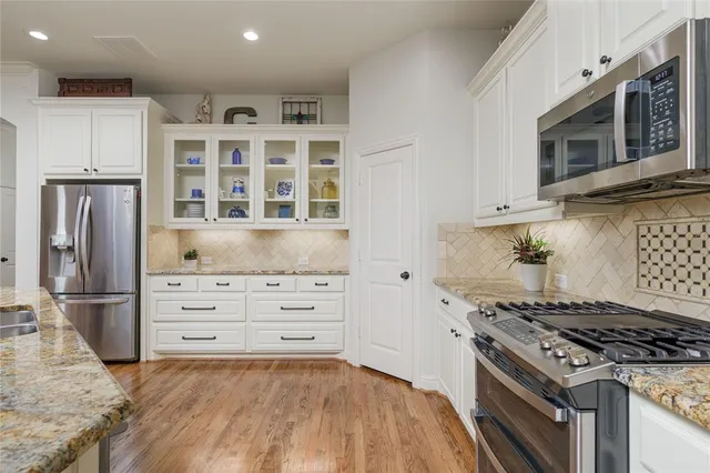 a kitchen with stainless steel appliances granite countertop a stove and a refrigerator