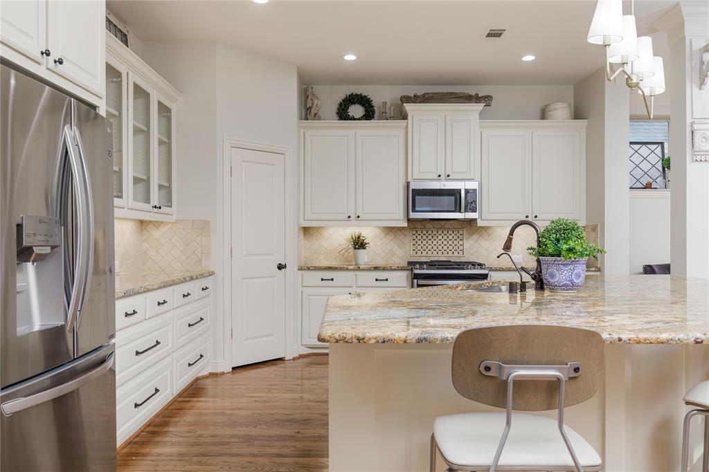 2205 State Boulevard McKinney, TX 75071 - Photo 9 of 40 a kitchen with granite countertop white cabinets and refrigerator