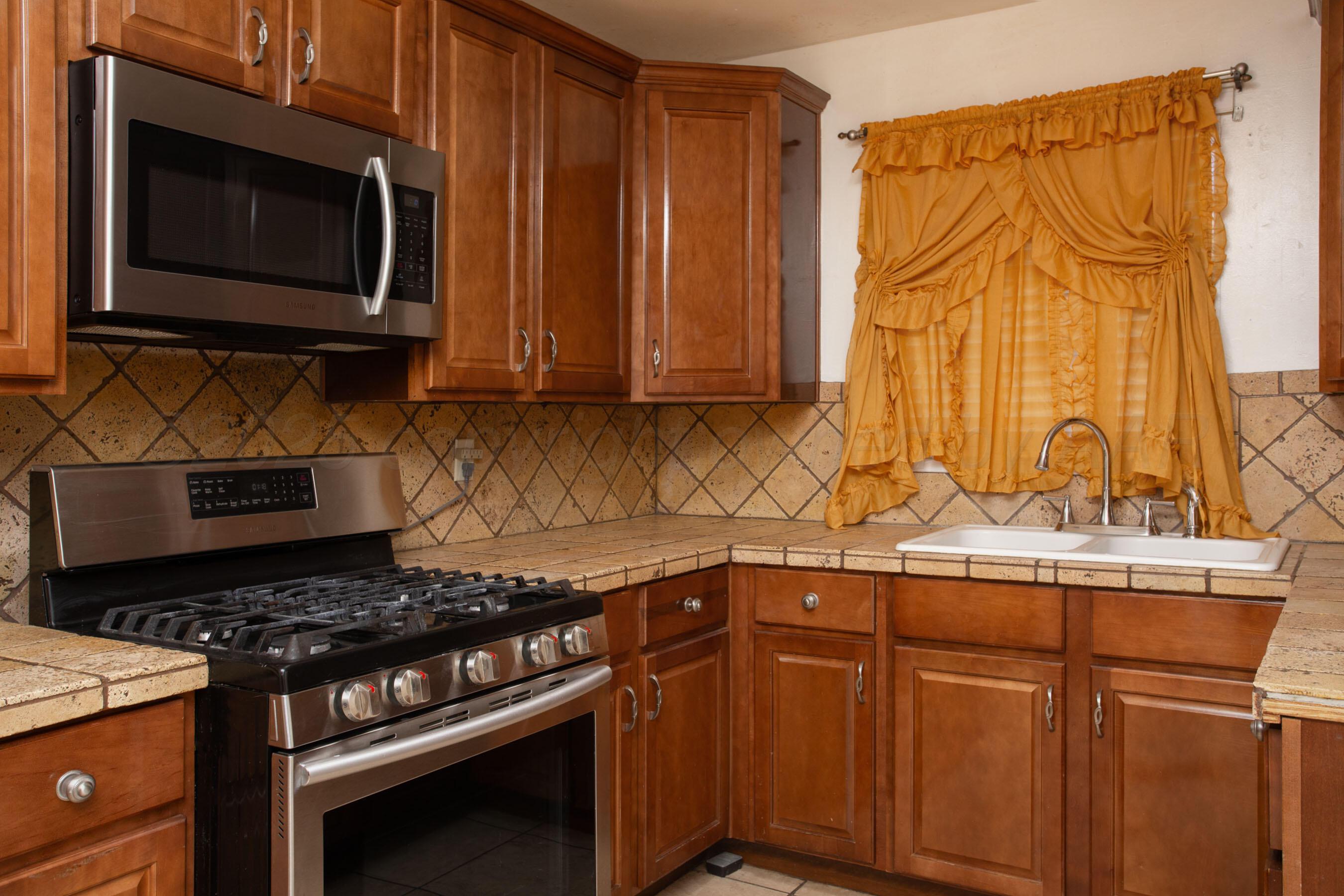 3115 Palm Street Amarillo, TX 79107 - Photo 11 of 31 a kitchen with granite countertop a stove and a microwave