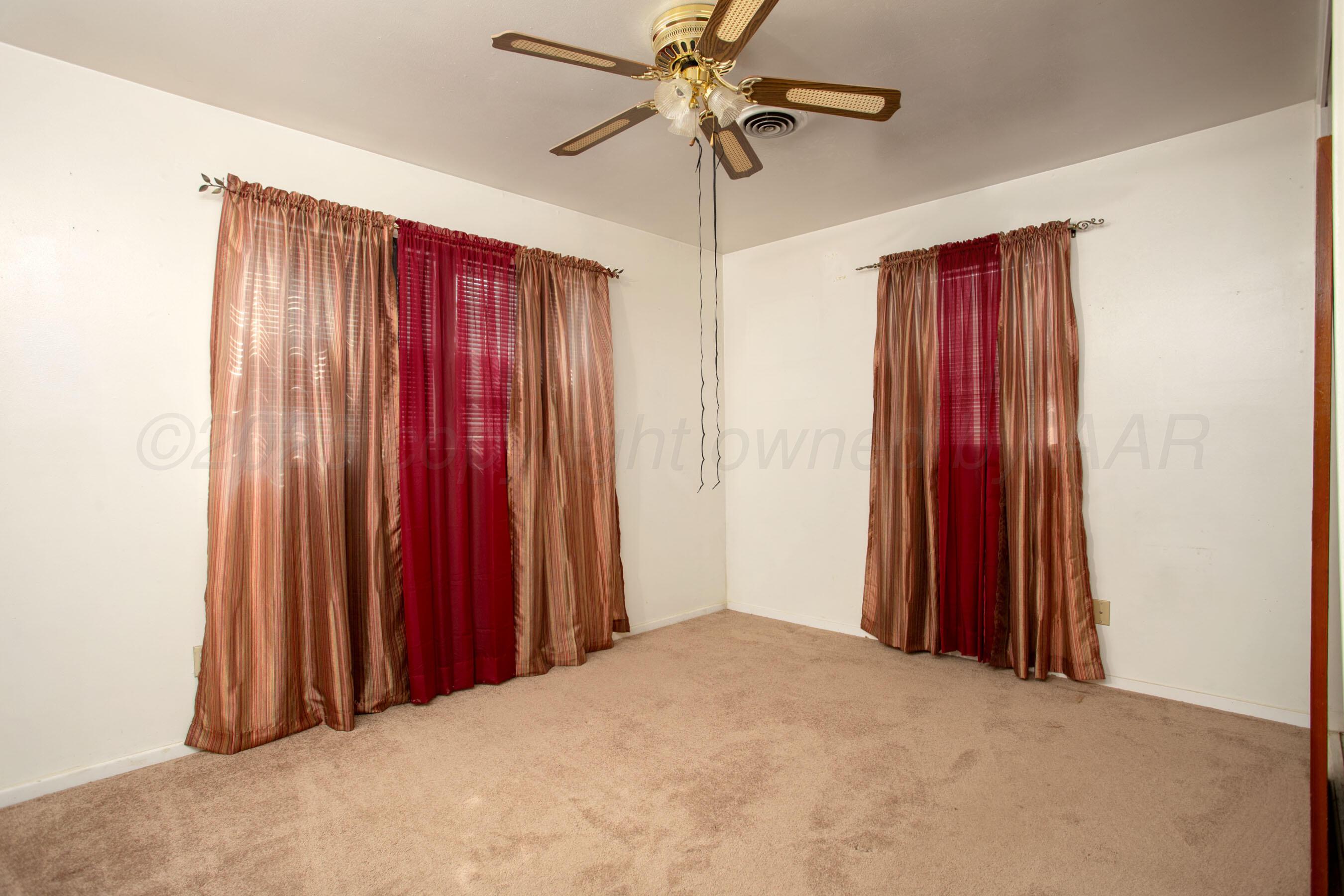 3115 Palm Street Amarillo, TX 79107 - Photo 24 of 31 a bedroom with a bed and a chandelier
