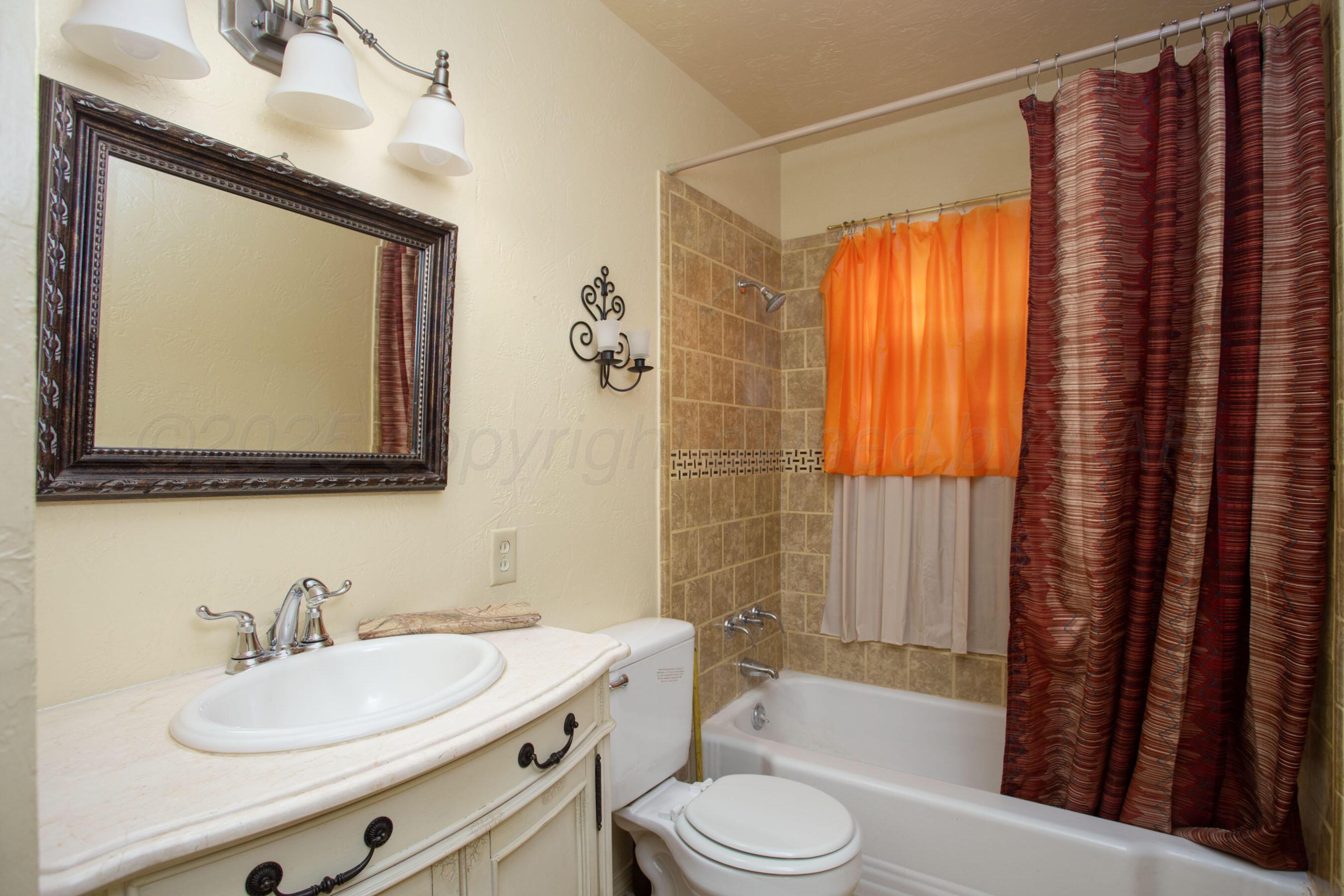 3115 Palm Street Amarillo, TX 79107 - Photo 26 of 31 a bathroom with a toilet a sink and a mirror