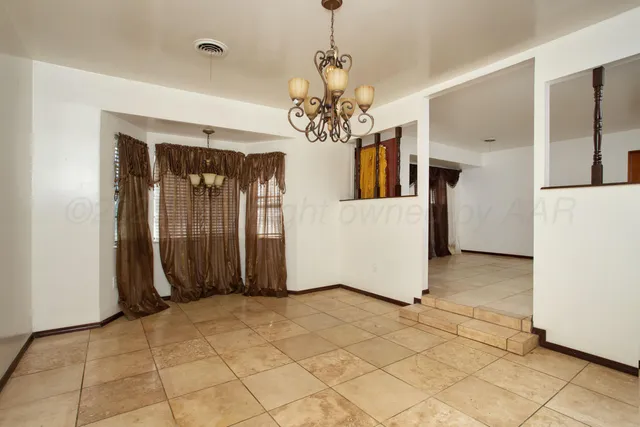 a view of a livingroom with chandelier and refrigerator