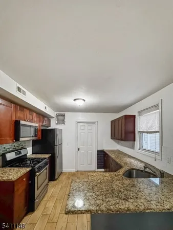 a kitchen with stainless steel appliances granite countertop a stove a sink and a microwave