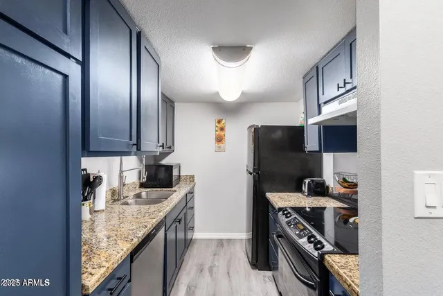 a kitchen with stainless steel appliances granite countertop a sink stove and refrigerator