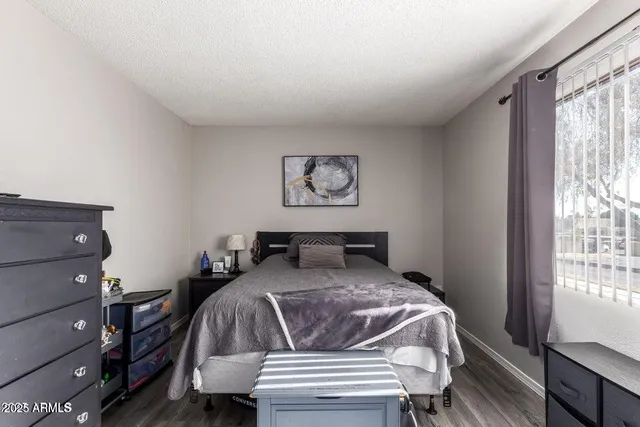 a bedroom with a bed and wooden floor