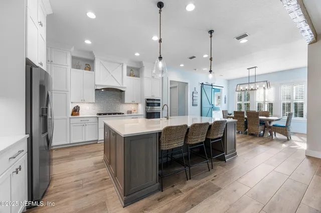 a kitchen with white cabinets and refrigerator