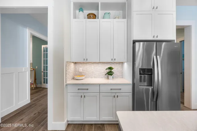 a large white kitchen with a stove and a refrigerator