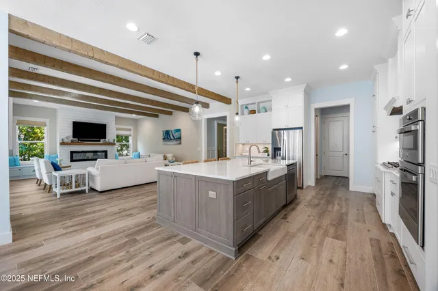 a large kitchen with stainless steel appliances granite countertop a lot of counter space and wooden floors