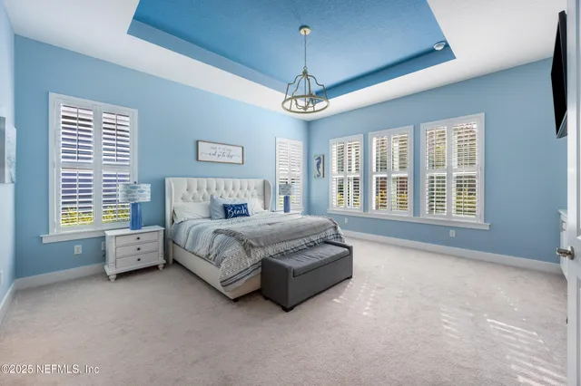 a bedroom with a bed and a chandelier