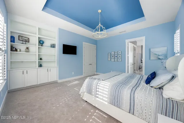 a bedroom with a large bed and a chandelier