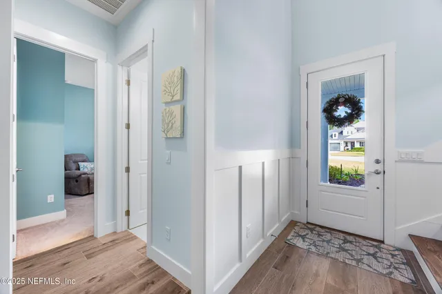 a view of entryway and hall with wooden floor