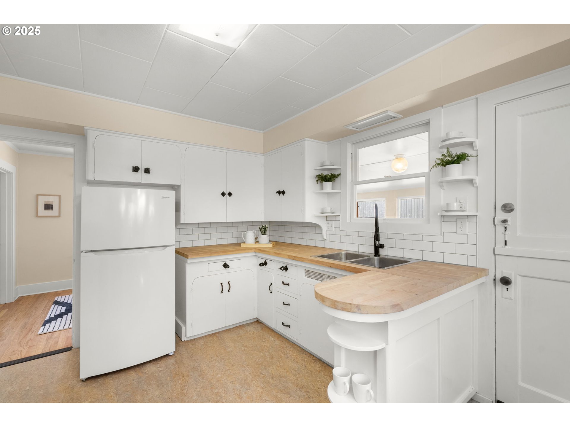1127 Southeast Sherrett Street Portland, OR 97202 - Photo 13 of 37 a kitchen with sink refrigerator and cabinets