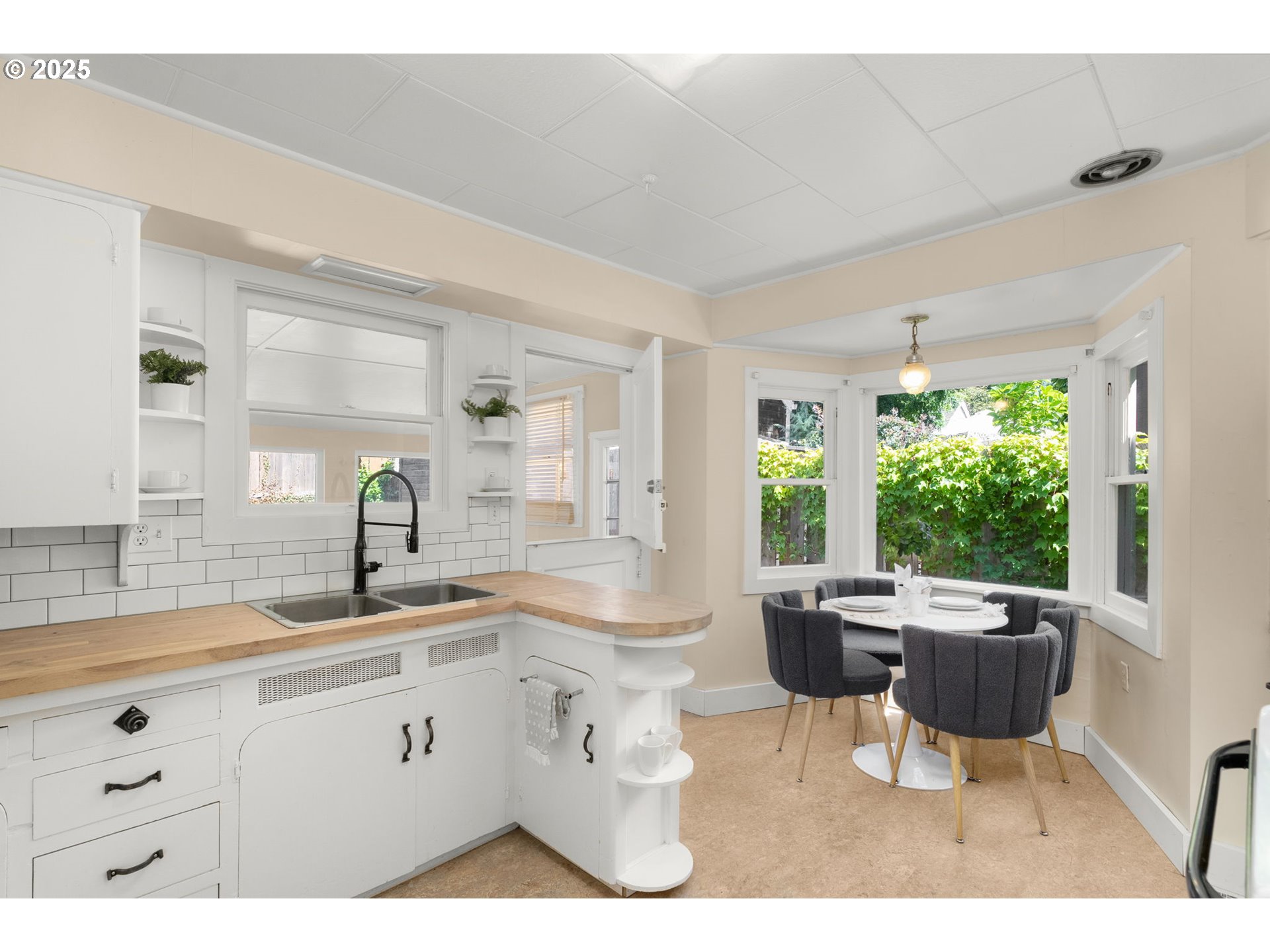 1127 Southeast Sherrett Street Portland, OR 97202 - Photo 14 of 37 a open dining room with kitchen island a sink wooden floor and a large window