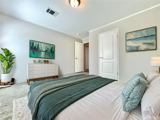 a bedroom with a bed and a painting on the wall