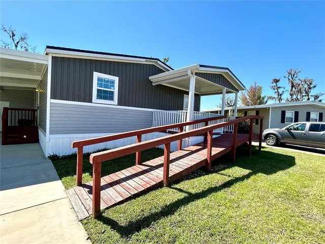 a view of a house with backyard and sitting area