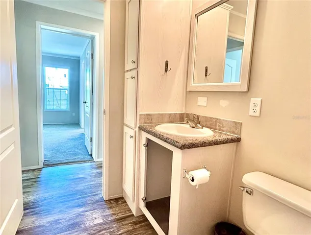 a bathroom with a granite countertop sink and a toilet