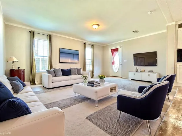 a living room with furniture flat screen tv and a large window