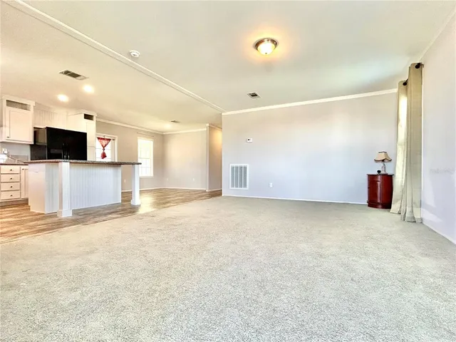 a view of a livingroom with kitchen and a window