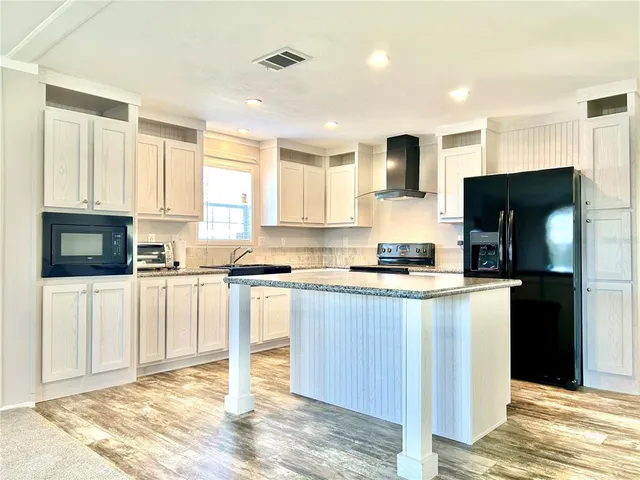 a kitchen with stainless steel appliances granite countertop a refrigerator stove microwave and sink