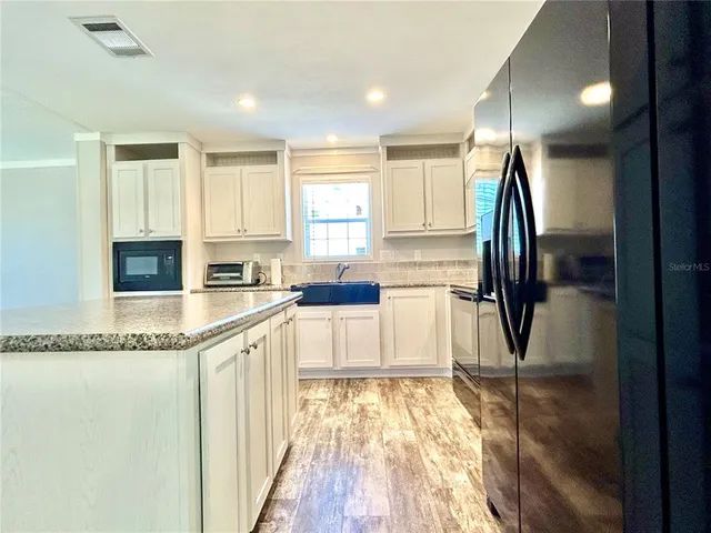 a kitchen with stainless steel appliances granite countertop a refrigerator and a sink
