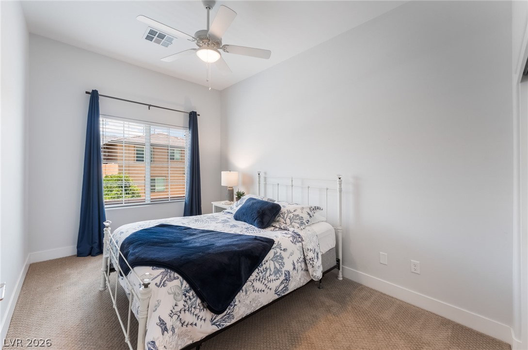 6432 Spring Jog Street Las Vegas, NV 89166 - Photo 35 of 61 A restful bedroom offers a window with natural light, complemented by a convenient ceiling fan.