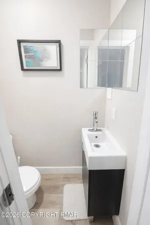 a bathroom with a toilet a sink and mirror