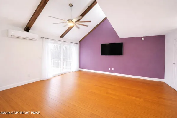 a view of an empty room with a ceiling fan and a window