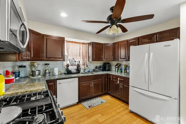 a kitchen with wooden cabinets and white appliances
