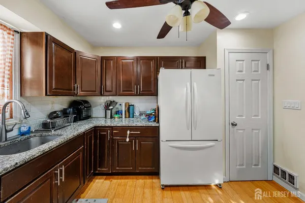 a kitchen with a sink a refrigerator and cabinets