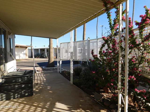 a view of a patio with table and chairs and floor to ceiling window