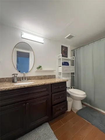a bathroom with a toilet a sink and mirror