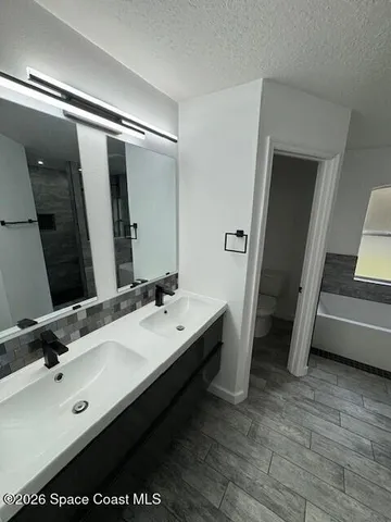 a bathroom with a double vanity sink and mirror