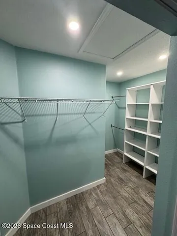 a view of a room with wooden floor and empty shelves