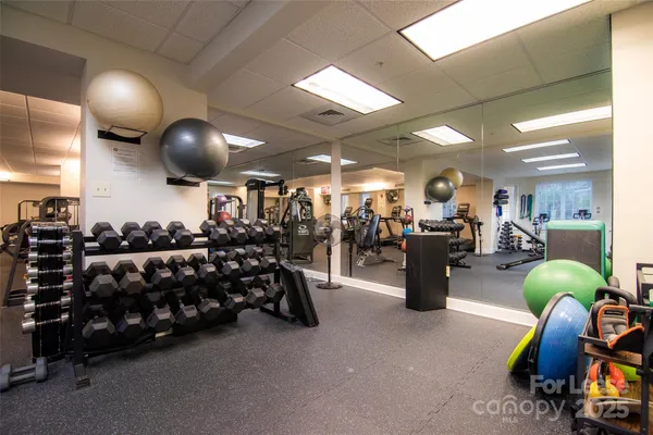 a living room with furniture a flat screen tv and kitchen view