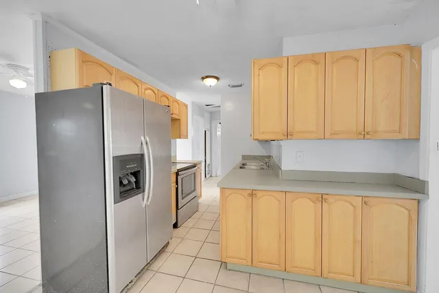 a kitchen with a refrigerator a sink and cabinets